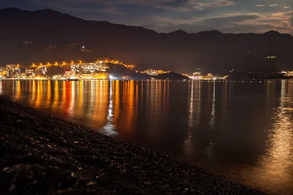 Seaside resort at night with mountains nearby and the moon light