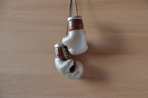 Old boxing gloves, leather boxing gloves, hanging on wooden wall.