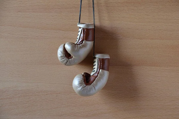 Old boxing gloves, leather boxing gloves, hanging on wooden wall.