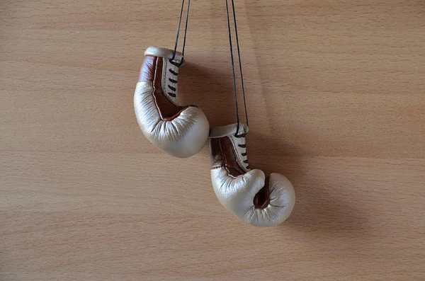 Old boxing gloves, leather boxing gloves, hanging on wooden wall.