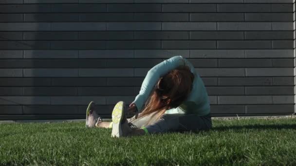 Jonge vrouw houdt zich bezig met Fitness op het gras — Stockvideo