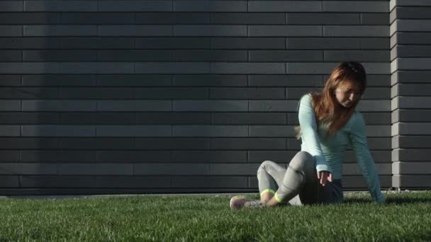 Jonge vrouw houdt zich bezig met Fitness op het gras — Stockvideo