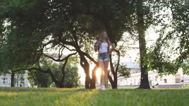 Menina bonita andando com seu pequeno cão no parque da cidade — Vídeo de Stock