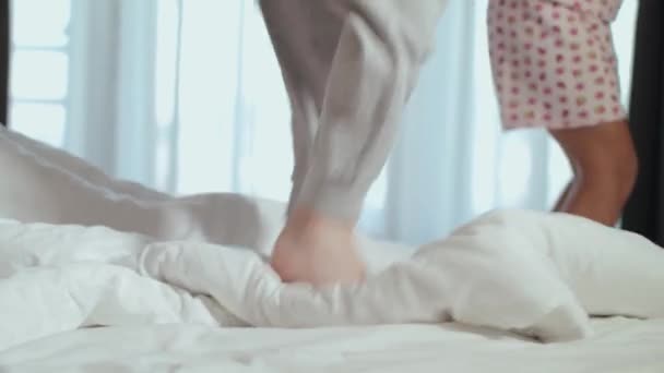Niños felices saltan en la cama de sus padres por la mañana — Vídeos de Stock