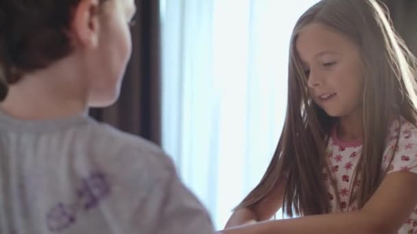 Niños felices saltan en la cama de sus padres por la mañana — Vídeo de stock