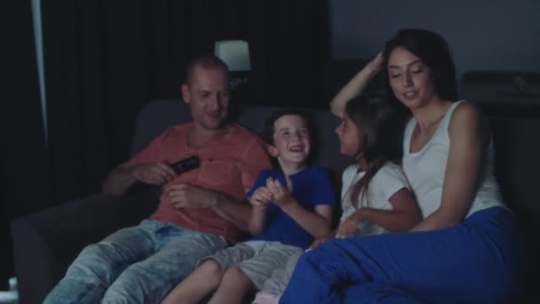 Семья смотрит телевизор в вечернее время . — стоковое видео