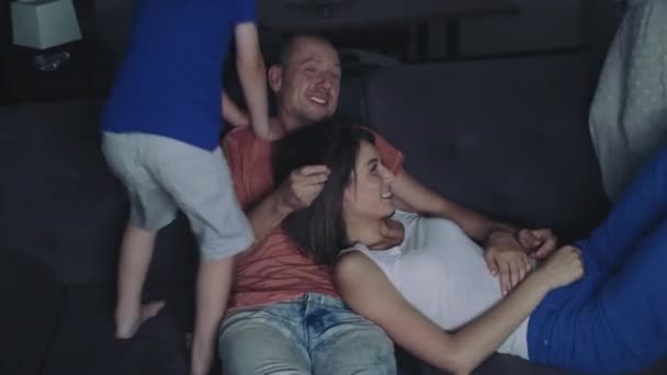 La famiglia sta guardando la TV la sera . — Video Stock