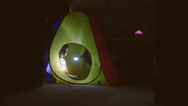 Dzieci bawią się w namiocie z latarkami. — Wideo stockowe