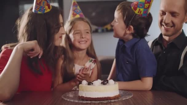 O menino morde um bolo de aniversário — Vídeo de Stock