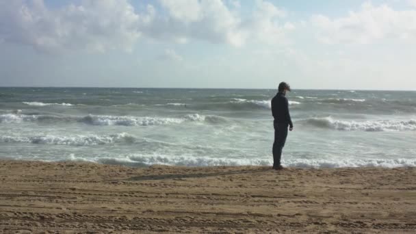 Un hombre concebido caminando en la playa del océano — Vídeo de stock