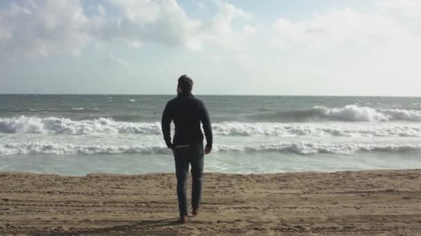 Un hombre concebido caminando en la playa del océano — Vídeo de stock