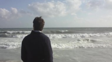 Okyanus plaj üzerinde düşünülmüş bir adam