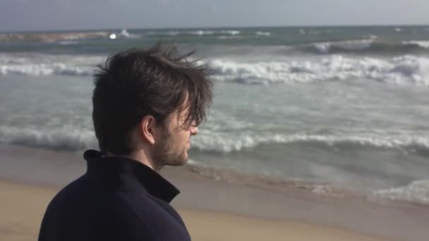 Okyanus plaj üzerinde düşünülmüş bir adam — Stok video