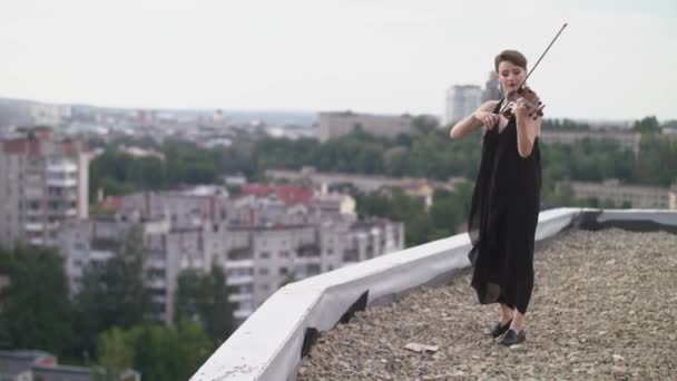 Bella giovane donna che suona il violino sul tetto . — Video Stock