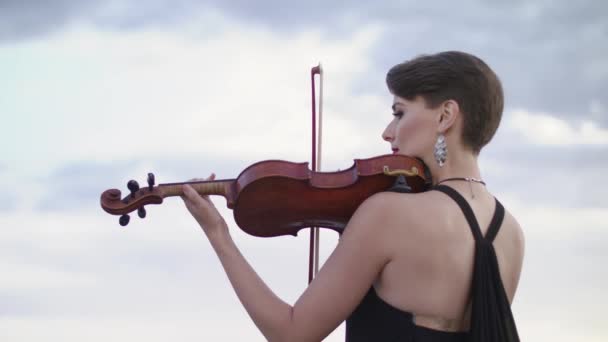 Hermosa joven tocando en el violín en el tejado . — Vídeos de Stock