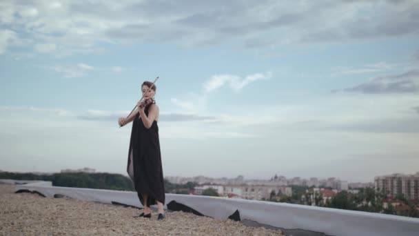 Bella giovane donna che suona il violino sul tetto . — Video Stock