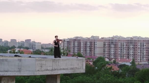 Hermosa joven tocando en el violín en el tejado . — Vídeos de Stock