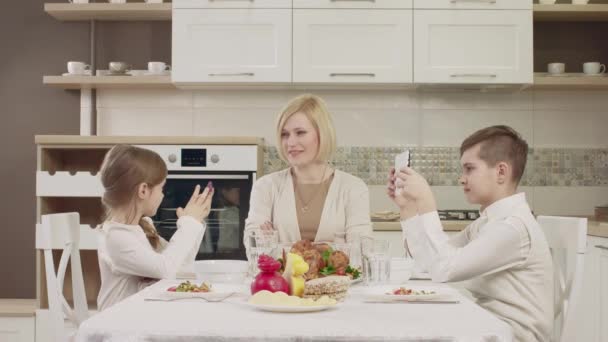 在家庭聚餐时, 妈妈和孩子们在餐桌上交流。 — 图库视频影像
