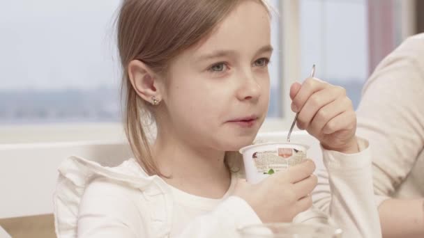 Menina come uma deliciosa musse de chocolate durante um jantar em família — Vídeo de Stock