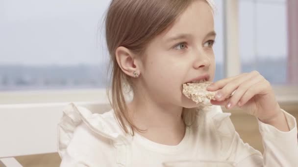 Meisje eet rijst brood tijdens een familiediner — Stockvideo