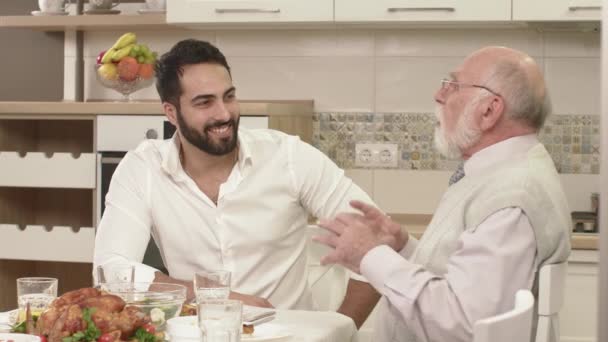 Conversación amistosa entre dos hombres durante una cena familiar — Vídeo de stock