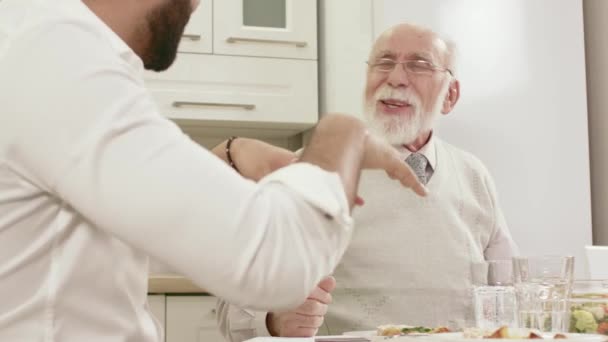 Přátelskou konverzaci mezi dvěma muži na rodinné večeři — Stock video
