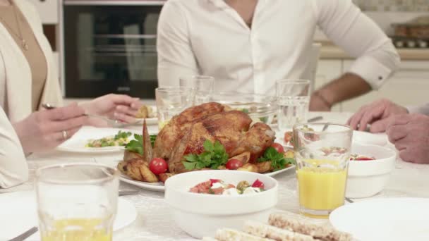 Familia sentada alrededor de una mesa, comiendo, comunicándose y divirtiéndose durante la cena familiar . — Vídeo de stock