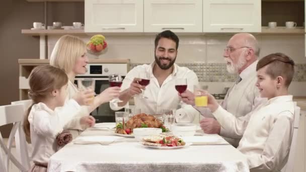 Familia sentada alrededor de una mesa, comiendo, comunicándose y divirtiéndose durante la cena familiar . — Vídeo de stock