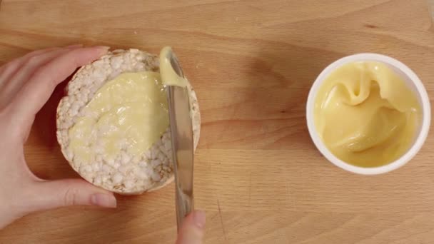 Ženské ruce šíření smetanový sýr na chleba. — Stock video