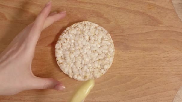 Mãos femininas espalhando creme de queijo no pão . — Vídeo de Stock