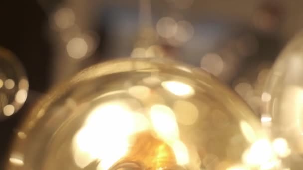 Expensive Large Chandelier Of Glass In A Restaurant Or Concert Hall. Chandelier Lighting In Hall, Bokeh, Glare, Glow, Defocus. — Stock Video