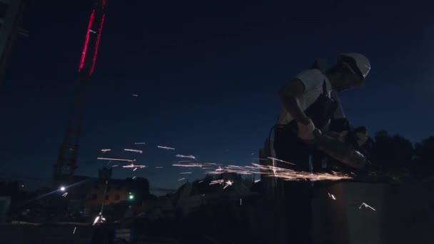 Der Mensch arbeitet mit einem elektrischen Schleifer. Hintergrund der Stadt. — Stockvideo