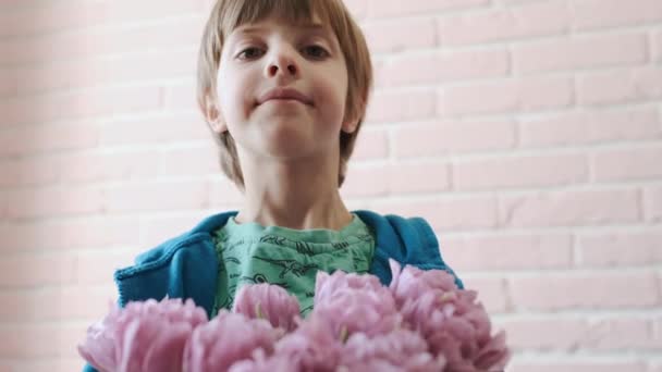 Portret van een kind met een boeket bloemen in zijn handen. Close-up. — Stockvideo