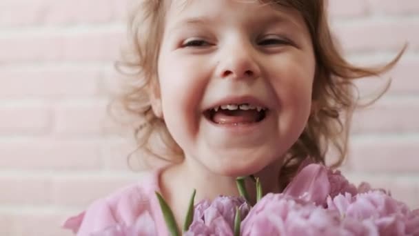 Portret van Kid met een boeket bloemen in zijn handen. Geluk. Close-up. — Stockvideo