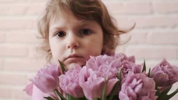 Portret van een kind met een boeket bloemen in zijn handen. Verdriet. Close-up. — Stockvideo