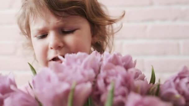 그의 손에 꽃다발을 들고 있는 아이의 초상화. 슬픔. 클로즈업. — 비디오