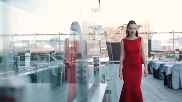 Hermosa chica en vestido formal rojo posando en la calle en el día soleado . — Vídeo de stock