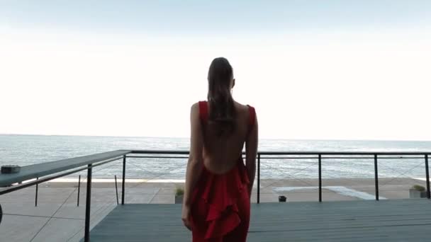 Belle fille en robe formelle rouge posant sur la rue le jour ensoleillé . — Video