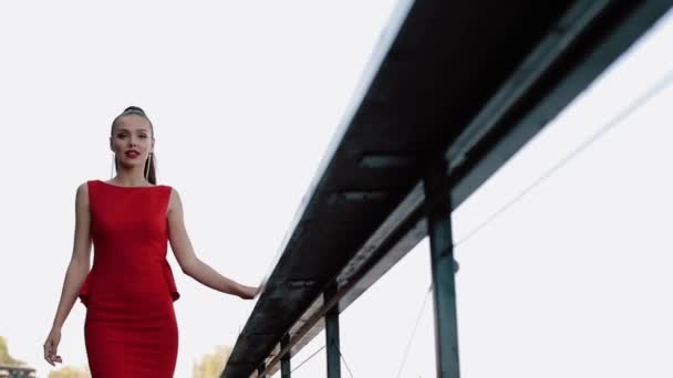 Menina bonita no vestido formal vermelho posando na rua no dia ensolarado . — Vídeo de Stock