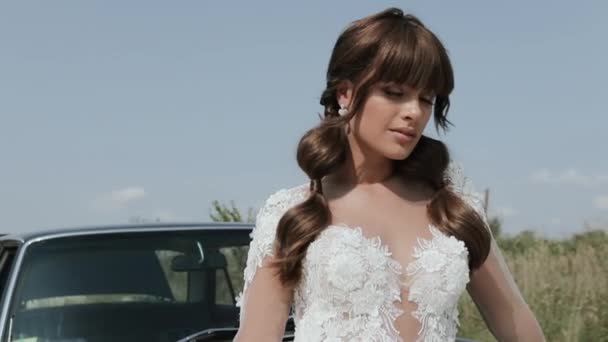 Joven hermosa mujer en vestido de novia posando cerca de coche Vintage . — Vídeos de Stock