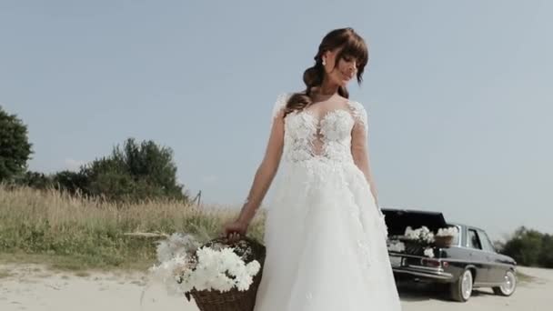 Joven hermosa mujer en vestido de novia posando cerca de coche Vintage . — Vídeos de Stock