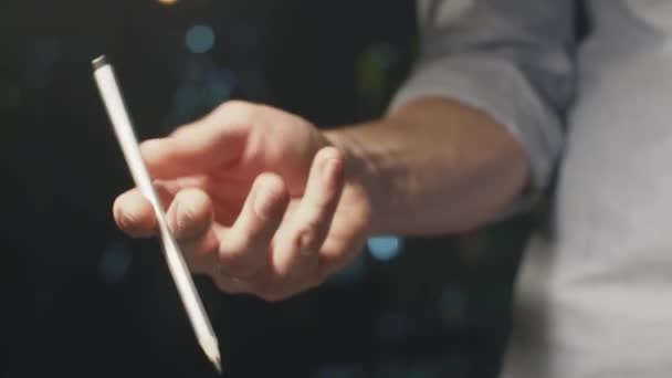 Ung man håller en penna i handen. Spel med en penna. Närbild. — Stockvideo