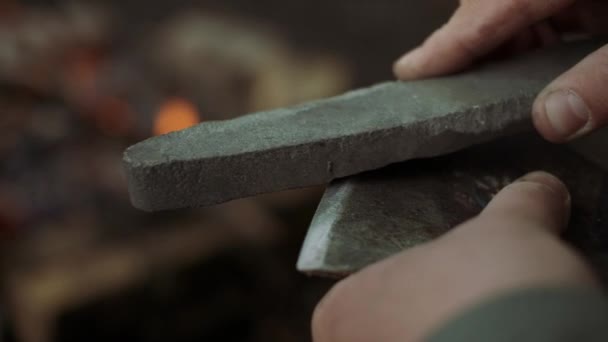 Wild Deciduous Forest Kampı'nda Sıcak Bonfire yakın Balta ve Keskinleştirme Taş ile Casual Strong Man İşleri Close-up. — Stok video