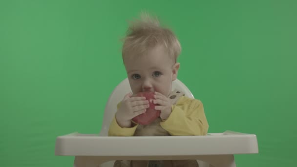 Fröhliches Baby, das Spaß hat und mit Apfel spielt. — Stockvideo