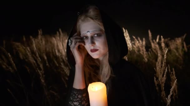 Imagen de Halloween. Retrato de una bruja joven. Bruja en negro con capucha Cabo . — Vídeo de stock
