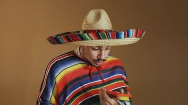Çok renkli pançolu ve şapkalı genç Meksikalı..