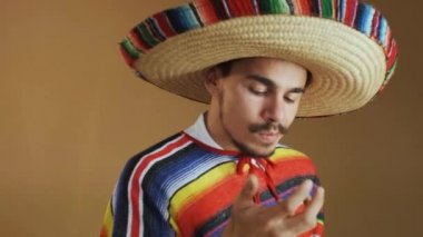 Çok renkli pançolu ve şapkalı genç Meksikalı..