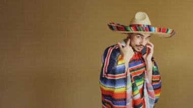 Çok renkli pançolu ve şapkalı genç Meksikalı..