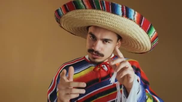 Młody Meksykanin w wielobarwnych ponczo i kapelusz. — Wideo stockowe