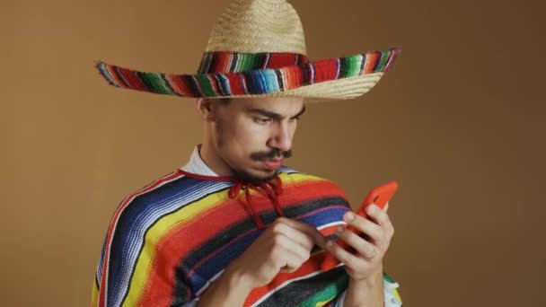 Joven mexicano en poncho multicolor y sombrero. — Vídeos de Stock